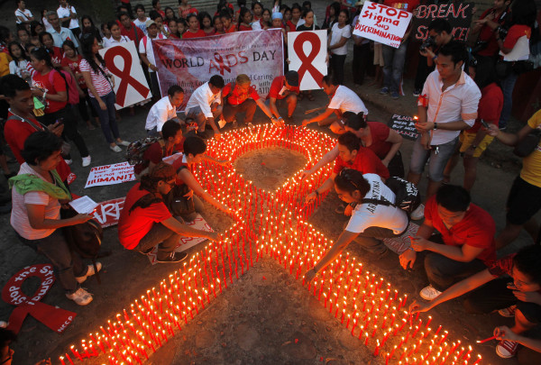 Supporters of people living with HIV and AIDS light candles to form a ribbon, to mark World Aids Day at Heroes Shrine in Quezon City